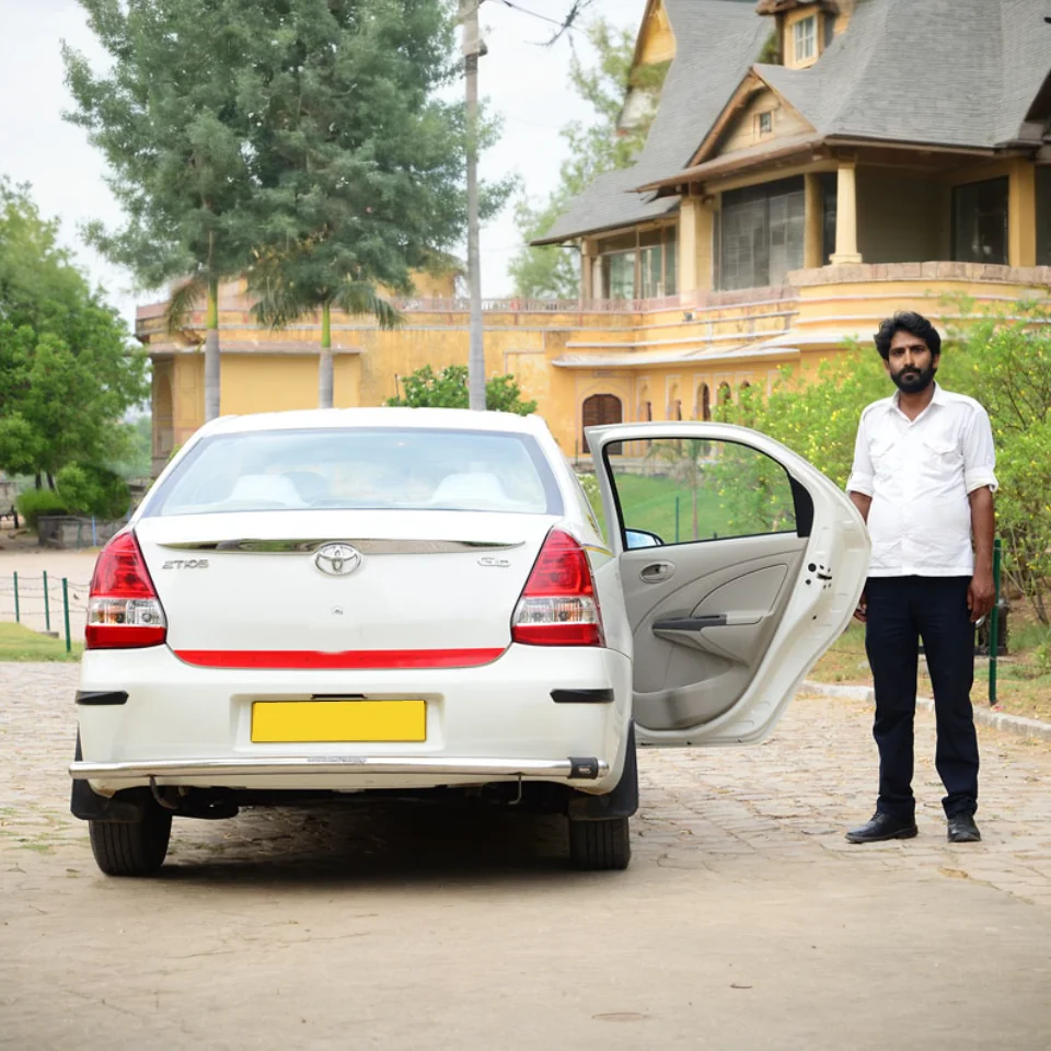 Driver beside a Toyota Etios